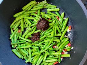 加入2汤匙虾酱，翻炒拌匀。没有虾酱，可以用蚝油或其它的酱，都没有就不放。加一点增香增鲜。