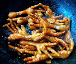 放入鸡爪翻炒均匀使每个鸡爪裹上料汁