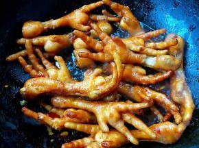 放入鸡爪翻炒均匀使每个鸡爪裹上料汁