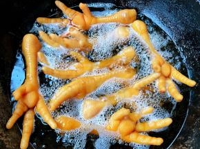 锅中倒入油加热放入鸡爪炸起来