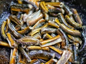 锅中热油，放入鳝鱼煎至变硬，