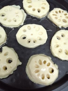 电饼铛中加入少许的油预热，然后把沾有面糊的莲藕片放入锅中