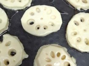 电饼铛中加入少许的油预热，然后把沾有面糊的莲藕片放入锅中