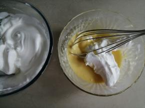 细砂糖和玉米淀粉拌匀，这里加入淀粉，是使打发好的蛋白霜更稳定。分三次加入到蛋清里，用电动打蛋器打至偏干性发泡的状态。取1/3打发好的蛋白霜放入到蛋黄糊里，划J字拌匀，左手逆时针转动打蛋盆