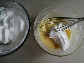 细砂糖和玉米淀粉拌匀，这里加入淀粉，是使打发好的蛋白霜更稳定。分三次加入到蛋清里，用电动打蛋器打至偏干性发泡的状态。取1/3打发好的蛋白霜放入到蛋黄糊里，划J字拌匀，左手逆时针转动打蛋盆