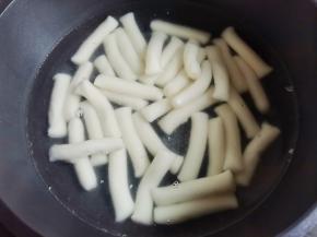 年糕泡凉水中化开，锅中加入一大碗水烧开，放入年糕煮至变胖后捞出，泡入凉水中备用。