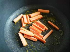 不粘锅中加入适量油烧至七成热，加入香肠煎至变硬，