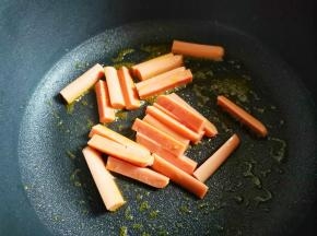 不粘锅中加入适量油烧至七成热，加入香肠煎至变硬，