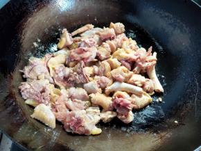 锅烧热，倒入40-50ml菜籽油，转动几下锅，让油将锅润一遍，然后倒入鸡块煸炒。