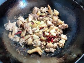 鸡块煎到变色后，将姜蒜和干辣椒加入，翻炒几下，再一起煎一会。