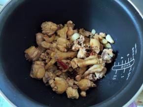 鸡肉煎得表面有点焦黄了，姜蒜香味也出来了，就转入电饭煲中。