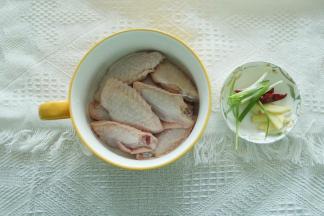 清洗干净的鸡翅中，放入干净碗里。葱切成葱段，干辣椒切碎备用。姜切成姜丝。