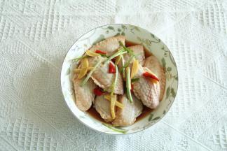 下班回家，取出冷藏的鸡翅，先将翅中码入盘中，再将腌制时候产生的料汁与姜丝等一起放在翅中上！