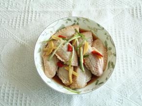 下班回家，取出冷藏的鸡翅，先将翅中码入盘中，再将腌制时候产生的料汁与姜丝等一起放在翅中上！