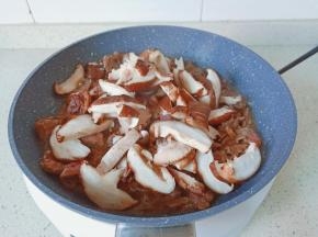 加入香菇片入锅。