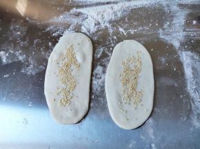 在饼胚表面抹一点水，然后洒上白芝麻，轻轻压一压。