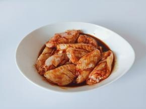 带上手套把鸡翅与调味料抓均匀。