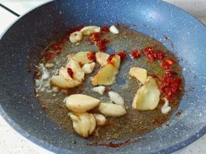 热锅凉油下生姜蒜与干辣椒煸炒出香味。