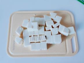 豆腐对半切开再切小块。【用刀在豆腐盒的两边各划一下，豆腐从盒子里轻轻松松就拿出来】