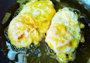 锅中热油打入鸡蛋，两面都煎至金黄盛出备用。