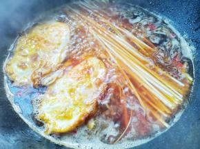 加入鸡蛋和面条，焖熟。