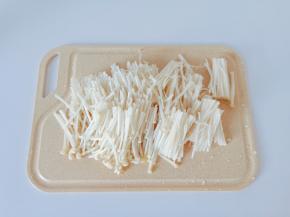 金针菇清洗干净，把尾部切除再对半切断一分为二。