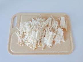 金针菇清洗干净，把尾部切除再对半切断一分为二。