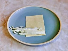 取一张豆皮，放上金针菇。