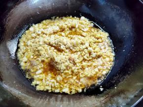 鱼干捞出后，锅里留一饭碗左右的底油，多余的装起。然后下姜末蒜末炸香。