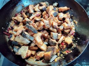 倒入前面炸好的鱼干，翻拌均匀，再煮五六分钟，中间要翻动几下。