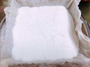 把过筛的粉一半用勺子轻轻舀到纱布里，用刮板轻轻的抹平不要压