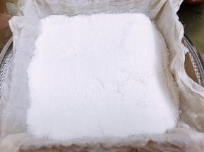把过筛的粉一半用勺子轻轻舀到纱布里，用刮板轻轻的抹平不要压