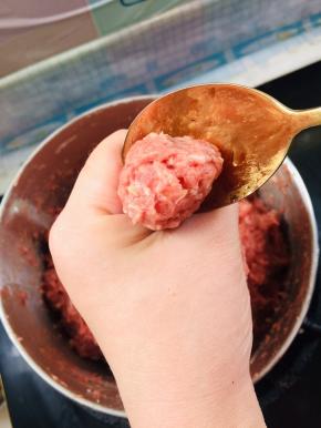 在虎口处把肉馅往出挤，用勺子把肉丸挖出来！