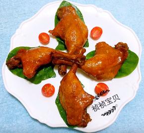 盘中用青菜叶和圣女果做装饰再摆上酱好的鸭腿就大功告成了