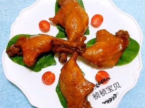 盘中用青菜叶和圣女果做装饰再摆上酱好的鸭腿就大功告成了