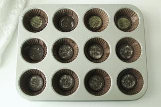 分离蛋黄和蛋白。蛋白放入干净无水无油盆中，放入冰箱冷冻备用。12连模放好纸托，奥利奥饼干去掉夹心，放入纸托底部，有花纹的朝下。