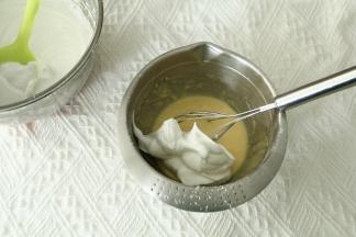 取1/3蛋白霜入蛋黄糊中，左手配合逆时针转盆，右手用蛋抽从2点钟方向切入，从盆底划到7点钟方向翻起到盆中心，重复切拌，翻拌动作，初步混匀。蛋抽不要提得太高，防止带入太多的空气，烤出的成品会有好多气孔。