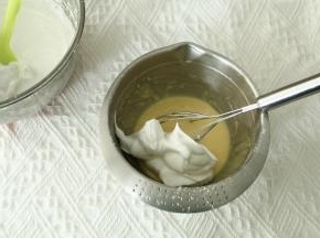 取1/3蛋白霜入蛋黄糊中，左手配合逆时针转盆，右手用蛋抽从2点钟方向切入，从盆底划到7点钟方向翻起到盆中心，重复切拌，翻拌动作，初步混匀。蛋抽不要提得太高，防止带入太多的空气，烤出的成品会有好多气孔。