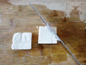 把一块豆腐先切十字，分成4小块，再从侧面分成2块，就是一大块豆腐切成了8小块。然后两面各划2下斜刀，切到中间就可以了，千万不要切断，两面的斜刀成90度夹角。