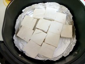 将煮好的豆腐晾下水，小心转入空气炸锅中，豆腐表面刷层油，200度烤6-8分钟左右。温度和时间仅供参考，豆腐两面要烤得微焦，外焦里嫩才好吃。