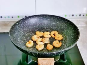 起油锅，加入腌制好的虾仁煸炒至变色，盛出备用。