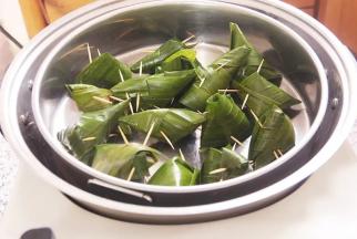 6.锅内胆加入1000毫升水，依次放上蒸架、蒸盘及香兰叶包鸡，中火烧开，定时蒸25分钟