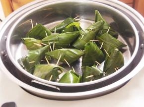 6.锅内胆加入1000毫升水，依次放上蒸架、蒸盘及香兰叶包鸡，中火烧开，定时蒸25分钟