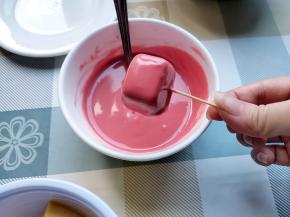 用牙签叉一块小雪糕，在巧克力糊中滚一圈，然后快速撒上坚果碎。