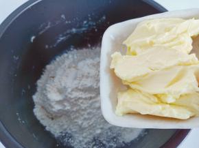 把黄油提前拿出来放在室温软化，加入中筋面粉先和均匀，再加入温水和成面团。