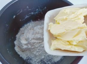 把黄油提前拿出来放在室温软化，加入中筋面粉先和均匀，再加入温水和成面团。