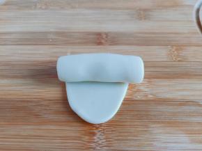 醒发好的面团擀成牛舌状，从上到下卷起来。