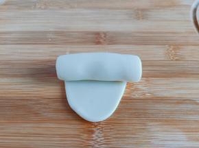 醒发好的面团擀成牛舌状，从上到下卷起来。