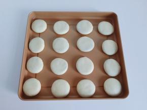 卷好的面团两端往中间捏一下再包上豆沙馅，放入烤盘。