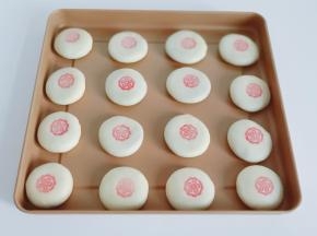 模具蘸上色素调的水，盖在面团上。